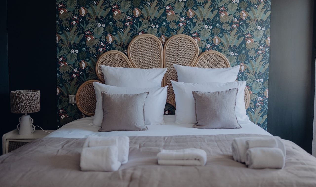 Chambre île aux oiseaux du château arnaud avec la tête de lit en forme de fleur et son papier pain jungle
