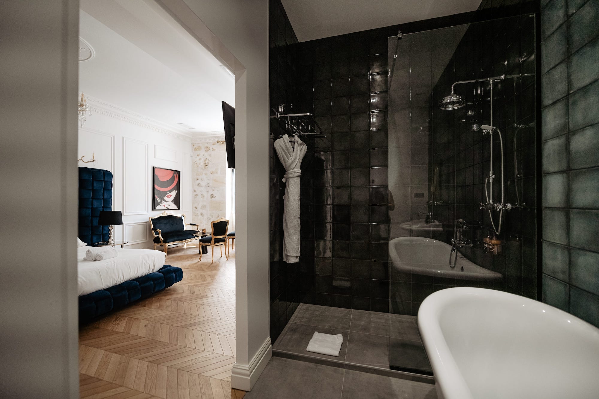 Salle de bain avec baignoire et douche à l'italienne de la suite Montesquieu du château grand arnaud